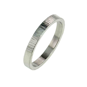 5 of 8: Angled view of a 3mm wide flat stainless steel ring featuring a vertical hand-chased texture and polished finish, displayed on a white background.