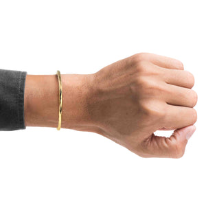 2 of 9: A Man's wrist wearing a 3mm Wide Hammered Solid Bronze Cuff Bracelet on a white background