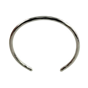 5 of 10: Overhead product photograph showing the oval shape of the 3mm Hammered Stainless Steel Cuff Bracelet by John S. Brana against a clean white background. Handcrafted from solid 316L surgical stainless steel, the bracelet features a continuous hand hammered texture, bright silver tone, gently rounded edges, and an open cuff design with smoothly finished ends. The photograph clearly displays the bracelet's curved construction and wrist opening.