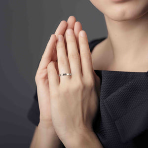 6 of 8: Close-up of a woman's hands with a 3mm Hammered Stainless Steel Flat Ring on a dark background