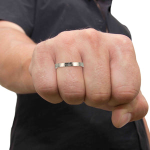 2 of 8: Close-up of a man's fist wearing a 3mm Hammered Stainless Steel Flat Ring on a white background
