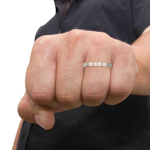 8 of 9: Close-up of a man's fist wearing a 3mm Matte Stainless Steel Flat Ring on a white background
