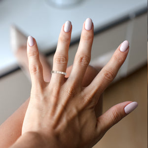 6 of 9: Hand with a3mm Matte Stainless Steel Flat Ring on a neutral background