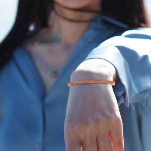 2 of 11: A Woman wearing a 3.5mm Wide Texturized Copper Cuff Bracelet  with a blurred background