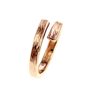 7 of 9: Side view of a slim handcrafted bronze bypass ring on a white background. The open band forms a modern wrap shape with two flat ends separated by a narrow gap. The outer surface shows a hand applied bark texture with reflective polished highlights, while the warm golden bronze finish gives the ring an organic, contemporary look.