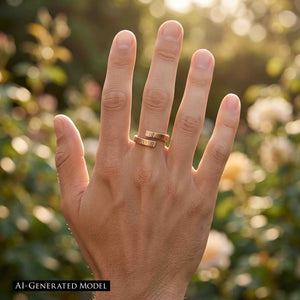 8 of 9: Close view of a hand wearing a polished chased bronze bypass ring outdoors. The ring has two narrow textured ends that overlap around the finger. Soft golden sunlight and blurred flowers create a warm garden setting.  AI Generated Model.