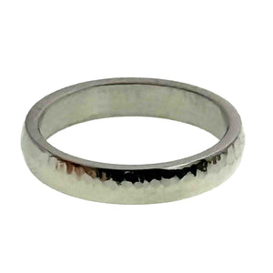 7 of 9: Low front view of a 4mm chased stainless steel domed ring on a white background. The narrow polished band shows a rounded exterior, scattered hand chased texture, dark reflections along the center, and a smooth flat inner surface.