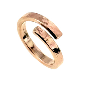 1 of 9: Three quarter view of the 4mm hammered bronze bypass ring on a white background. The open wrap shape, overlapping ends, polished edges, and reflective hammered surface are visible.