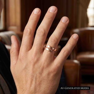 8 of 9: Close view of an adult man's hand wearing a polished hammered bronze bypass ring on the ring finger. The warm bronze band stands out against a softly blurred brown interior. An AI generated model label appears at the lower right.