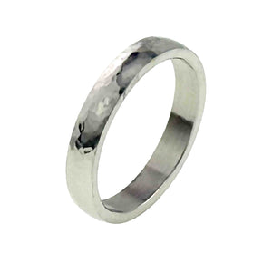 7 of 10: A 4mm hammered stainless steel domed ring is shown at a right facing angle on a white background. The view highlights the reflective hammered surface, smooth flat interior, rounded outer shape, and narrow polished edges.