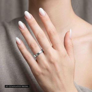 2 of 10: A woman wearing a soft gray top raises her left hand against a pale background. The 4mm hammered stainless steel domed ring sits on her ring finger and pairs with glossy white almond shaped nails. An AI generated model notice appears at the lower left.