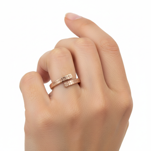 2 of 8: A hand wearing the 4mm Linen Bronze Bypass Ring, showcasing its open-ended wrap design and hand-applied linen texture. The warm, reddish tone of the raw bronze contrasts naturally against the skin, highlighting the ring’s artisanal craftsmanship. The textured surface adds depth and a rustic feel, making it suitable for both casual and special occasions. The ring fits comfortably and has a bold, modern yet earthy look.