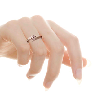 7 of 8: A woman wearing the 4mm Linen Bronze Bypass Ring on her middle finger. The ring features an open wrap-around design with a hand-applied linen texture and warm bronze tone. Its crosshatched surface adds a rustic, artisan-made feel. The delicate hand pose highlights the ring’s minimalist yet bold look, making it perfect for everyday wear or as a thoughtful anniversary gift.