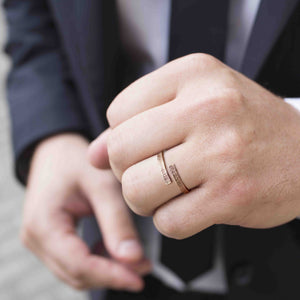 4 of 8: A man wearing the 4mm Linen Bronze Bypass Ring, styled with a suit and tie. The ring’s open-ended wrap design and hand-applied linen texture are clearly visible, adding a touch of rustic elegance to the formal outfit. The warm bronze tone stands out subtly against the skin, making it a versatile unisex accessory suitable for both everyday wear and special occasions like anniversaries or weddings.