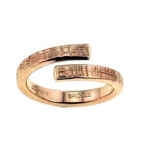 3 of 8: Close-up view of the 4mm Linen Bronze Bypass Ring showcasing its open wrap-around design and hand-applied linen texture. The raw bronze surface features a subtle crosshatch pattern that gives the ring a rustic, handcrafted look. The warm bronze tone adds an earthy, vintage feel, making it suitable for both men and women who appreciate minimalist, artisan-made jewelry.