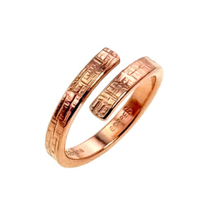 7 of 9: Handmade copper bypass ring with a linen textured finish, shown from an angled view highlighting the open wrap design on a white background
