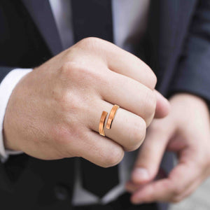 2 of 9: A man in a dark suit showing off a 4mm matte copper bypass ring on his hand, highlighting the warm tone of the copper against his formal attire.