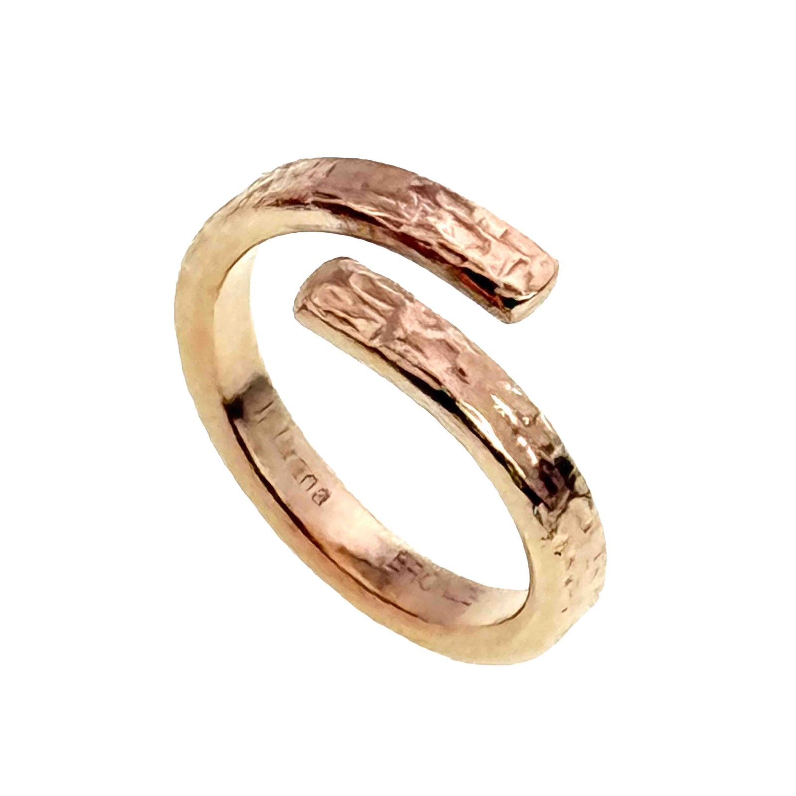 Angled view of the texturized bronze bypass ring on a white background. The open cuff style band curves around a central gap, with polished edges and textured rectangular ends that catch the light.