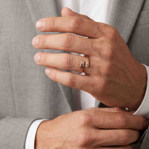 6 of 9: Close view of a man wearing the bronze bypass ring with a light gray suit and white shirt. The ring’s warm color and textured open ends create a stylish contrast against the tailored clothing.