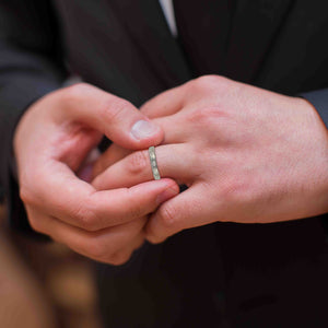 8 of 10: Close-up of hands with a 4mm Bark Stainless Steel Comfort Fit Ring on one finger, blurred background