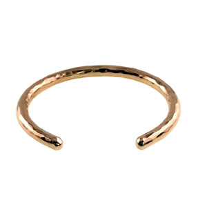 8 of 10: Front view of the handmade 5.25mm hammered bronze cuff bracelet by John S. Brana against a white background. The solid bronze bracelet features a polished golden finish, individually hammered surface, rounded ends, and an open cuff design. The visible opening illustrates the bracelet's rigid construction and curved shape, making proper wrist sizing important for a comfortable fit.