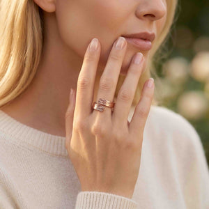 6 of 9: Close view of a woman wearing the bark copper bypass ring with a cream sweater, showing the textured copper wrap design, polished finish, and warm metal color against a soft neutral outfit.