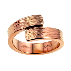 5 of 9: Front studio close up of the 5.5mm bark copper bypass ring on a white background, showing the open bypass shape, bark textured copper surface, polished edges, and stamped marks inside the solid copper band