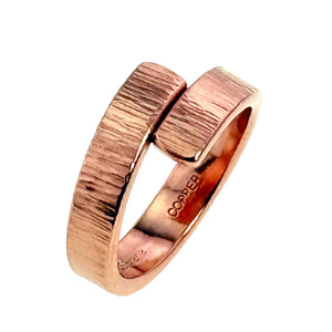 5 of 8: Angled side view of a chased copper bypass ring on a white background. The image shows the overlapping textured ends, polished inner band, substantial 2.25mm thickness, and stamped copper and maker marks inside the ring.