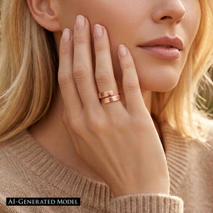 6 of 8: Close view of a woman wearing a 5.5mm chased copper bypass ring while resting her hand against her face. Warm sunlight highlights the polished copper surface, overlapping open ends, and fine hand applied texture.  AI Generated Model.