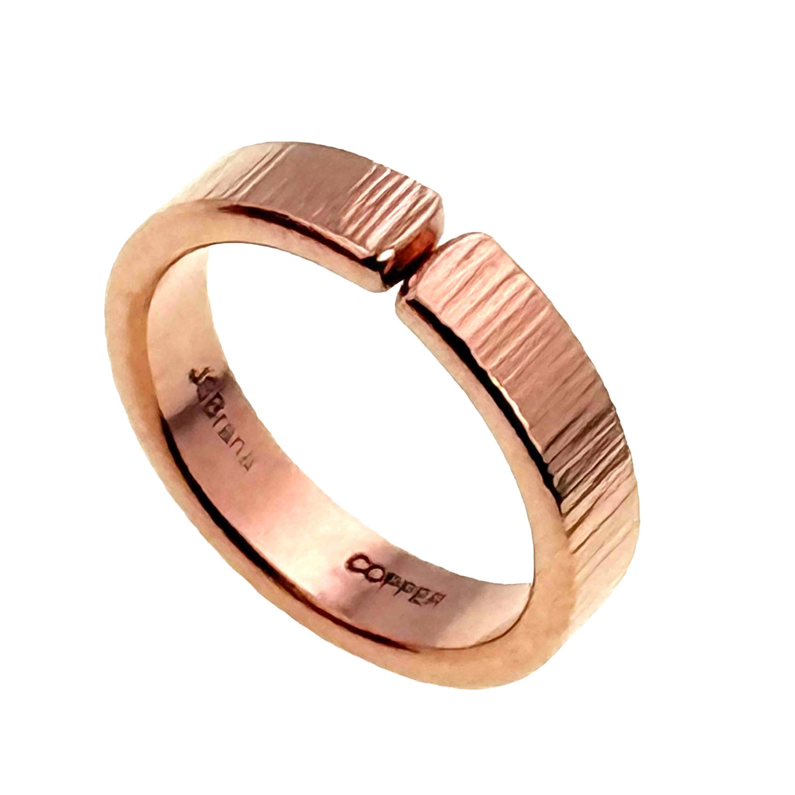 Studio product photo of a 5.5mm chased copper cuff ring viewed from a different angle on a white background. The image shows the warm copper color, open cuff gap, vertical chased marks, and smooth inner band.