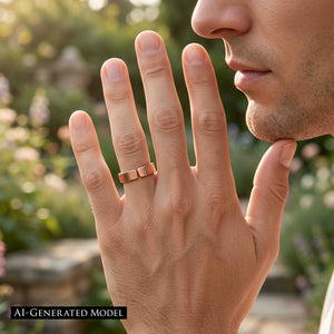 5 of 8: Close up lifestyle photo of a man wearing a 5.5mm chased copper cuff ring on his finger outdoors. The open cuff design and polished copper surface are visible against a softly blurred garden background.  AI Generated Model.