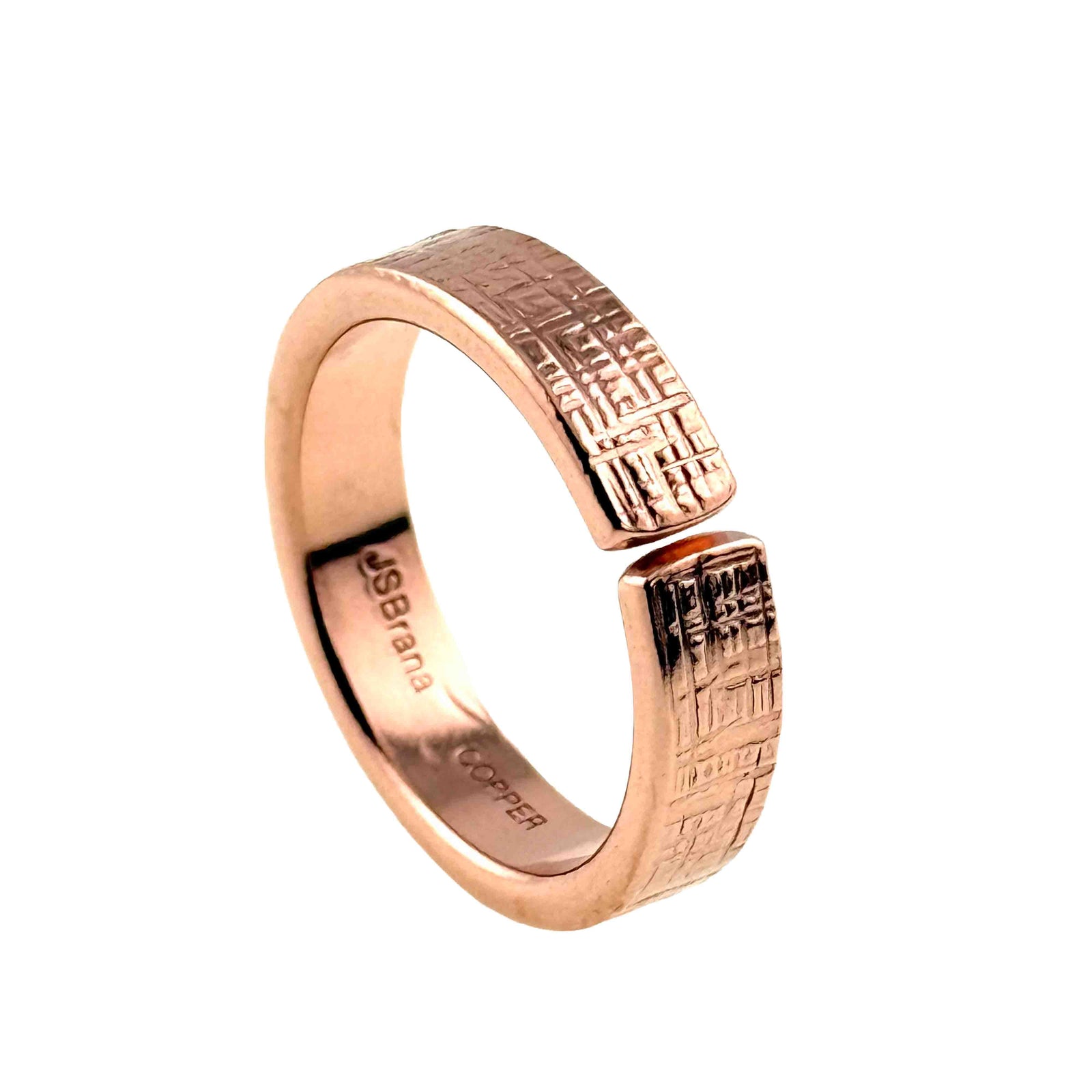 5.5mm wide linen textured copper cuff ring with an open adjustable band design. The ring features a hand applied woven fabric pattern on the outer surface and a smooth polished interior stamped with “JSBrana” and “COPPER.” Crafted from raw solid copper, the band has a warm rose gold tone and a 2mm thickness, shown against a plain white background.