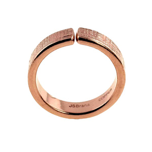 5 of 8: Front facing close-up of a 6mm linen textured copper cuff ring with an open adjustable band and small gap at the top. The outer surface features a hand applied woven fabric pattern with a polished finish. The interior is smooth and stamped “JSBrana” and “COPPER.” Crafted from solid raw copper with a warm rose gold tone, shown against a clean white background.