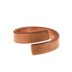 5 of 9: Side view of a matte copper bypass ring on a white background, highlighting the open cuff shape, smooth curved band, squared ends, and soft brushed copper surface.