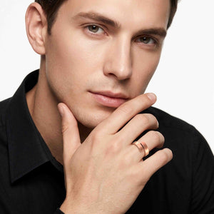 2 of 9: Man wearing a matte copper bypass ring with a black shirt, showing the unisex open wrap design, brushed copper finish, and sleek modern look.