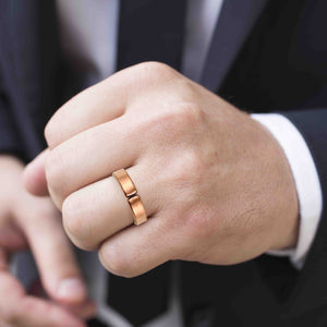 2 of 10: Man's Hand wearing a 5.5mm Matte Copper Cuff Ring with a blurred background