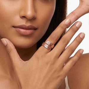 4 of 9: Woman wearing a 5.5mm texturized copper bypass ring near her face, showing the ring’s warm copper tone, open wrap shape, polished edges, and hand chased textured surface.
