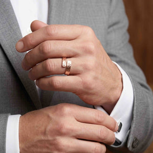 7 of 9: Man in a gray suit wearing a 5.5mm texturized copper bypass ring, showing the unisex ring’s polished copper finish, textured surface, and modern open wrap style for dress wear.