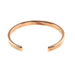 7 of 9: A handcrafted 5mm wide bronze cuff bracelet shown from a top-down angle, highlighting its open-ended design. The bracelet features a subtle bark texture along the outer surface and a smooth, polished inner band. The warm bronze tone adds an earthy, elegant touch to the minimalist style.