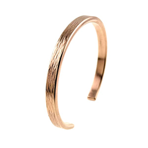 3 of 9: A handcrafted 5mm wide bronze cuff bracelet featuring a hand-applied bark texture along the outer surface. The bracelet has a warm, reddish-gold hue with a smooth, polished interior and an open-ended design for easy wear. Its natural, woodgrain-like pattern adds a rustic yet refined touch.