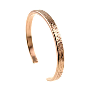 1 of 9: A handcrafted bronze cuff bracelet with a 5mm width, featuring a subtle bark-like texture on the outer surface. The bracelet has a warm, golden-brown finish with a smooth, polished interior and a gently curved open-ended design.