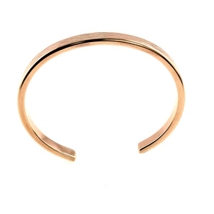 5 of 9: A handcrafted bronze cuff bracelet viewed from above, showcasing its open-ended design. The bracelet has a warm, reddish-gold finish with a smooth interior and a subtle bark texture on the outer surface. Its clean, curved shape and 5mm width create a sleek, minimal look with a natural twist.
