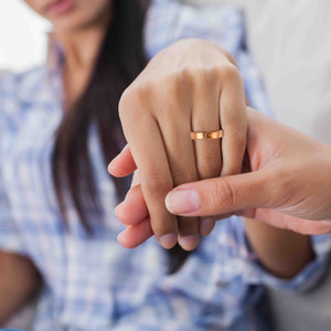 4 of 9: Close-up of a couple holding hands, with the woman wearing the 5mm Hammered Copper Cuff Ring on her finger.