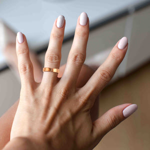 8 of 9: Woman wearing the 5mm Hammered Copper Cuff Ring on her middle finger, showing its polished finish and comfortable fit.