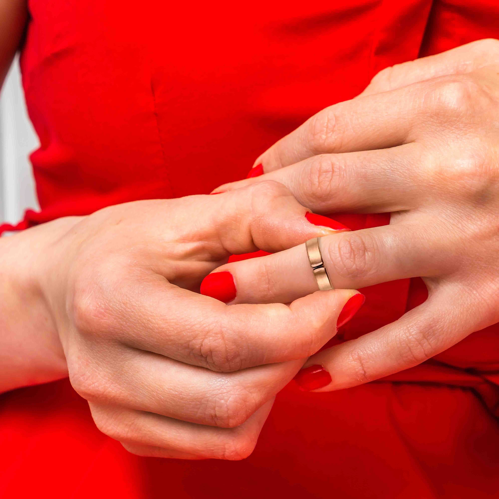 Close-up of a woman's hands with a 5mm Matte Copper Cuff Ring wearing a red dress