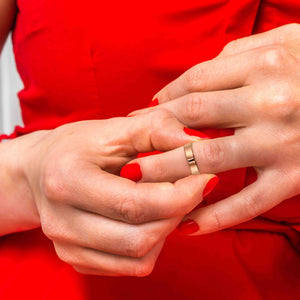 8 of 10: Close-up of a woman's hands with a 5mm Matte Copper Cuff Ring wearing a red dress