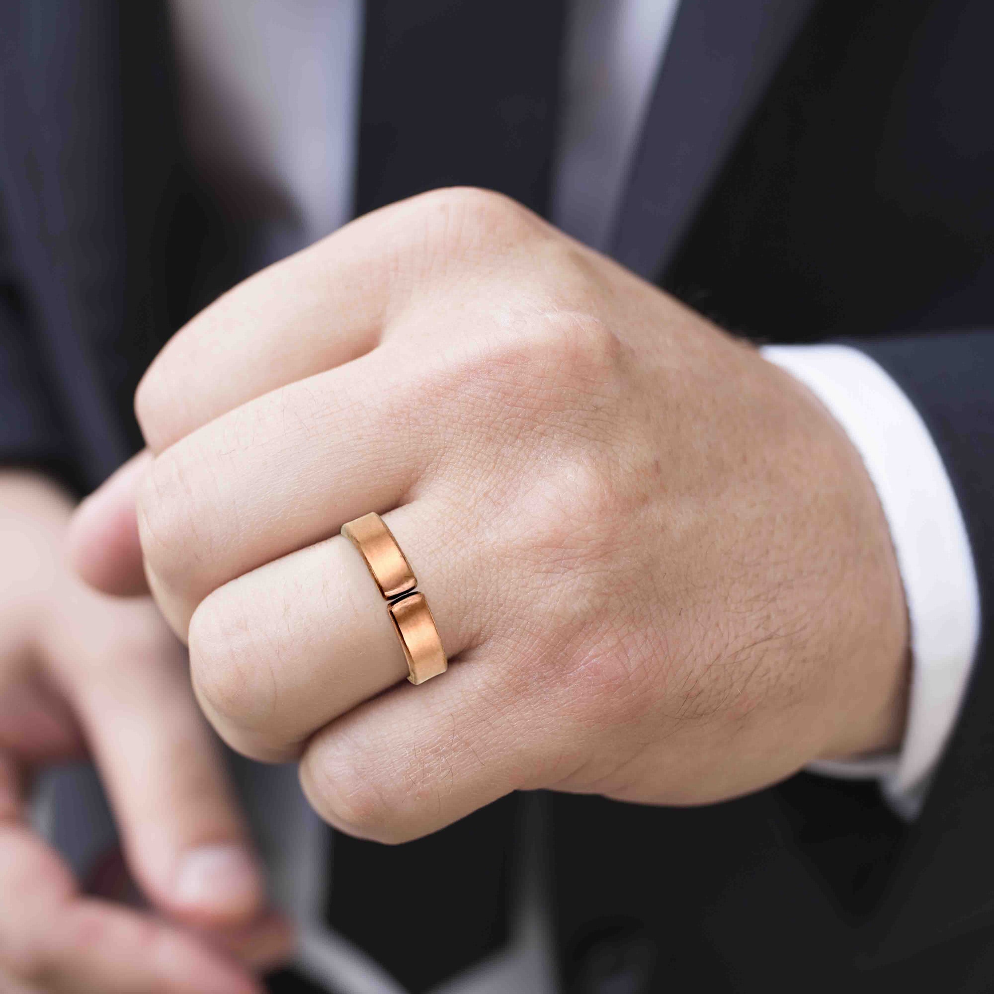 Man's Hand wearing a 5mm Matte Copper Cuff Ring with a blurred background