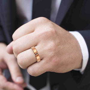 2 of 10: Man's Hand wearing a 5mm Matte Copper Cuff Ring with a blurred background