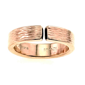3 of 9: Front-facing close-up of a 6mm solid bronze cuff ring with a hand-applied bark texture. The open band design features a small gap at the top, showing the adjustable cuff style. The outer surface has an organic, tree bark-inspired pattern, while the inner band is smooth and polished with a visible “Bronze” stamp. The warm golden-copper tone stands out against a light gray background.