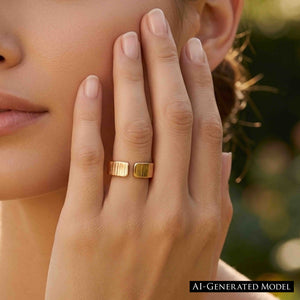 2 of 9: Woman wearing a 6mm chased bronze cuff ring while resting her hand against her cheek outdoors. Warm natural light brings out the polished bronze color, open cuff design, and hand applied vertical texture against a softly blurred garden background.  AI Generated Model.